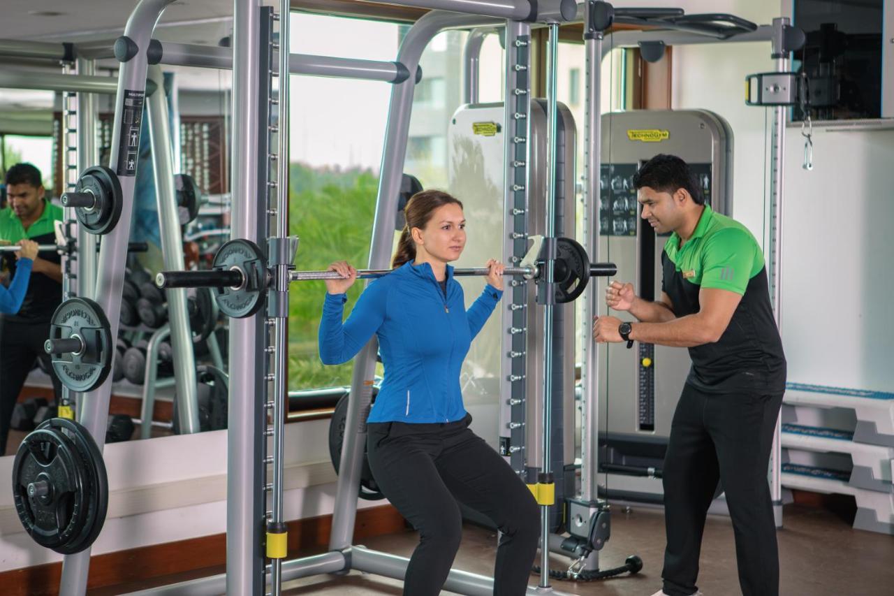 Jumeirah Messilah Beach Kuwait Kuwait City Exteriér fotografie A personal trainer assisting a woman with a squat