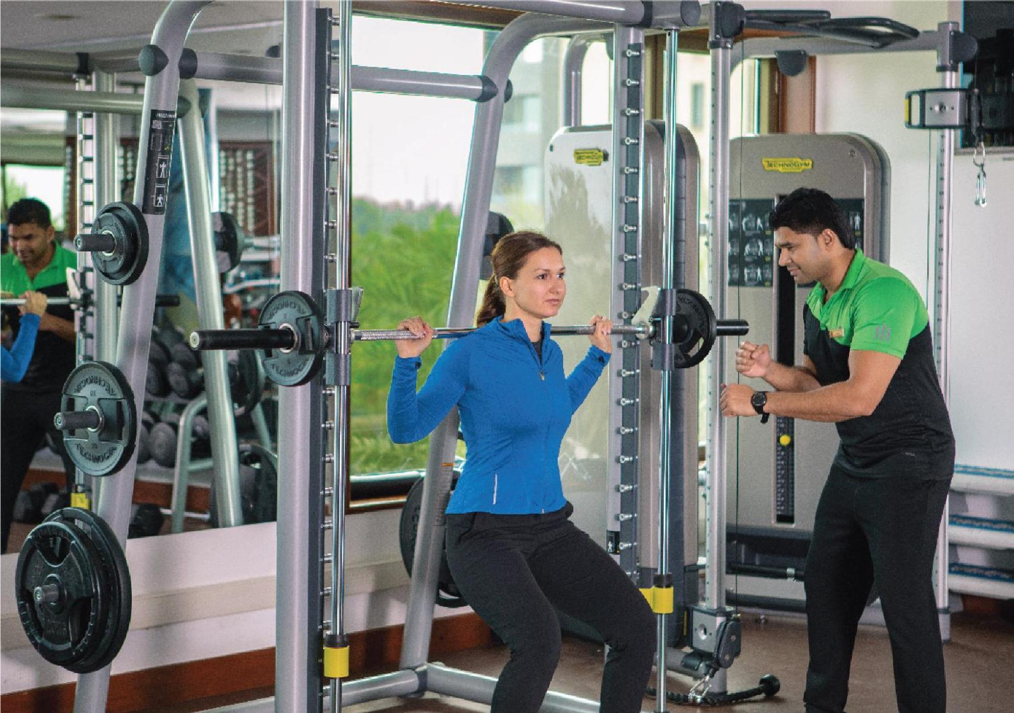 Jumeirah Messilah Beach Kuwait Kuwait City Exteriér fotografie A personal trainer assisting a woman with a weight training exercise